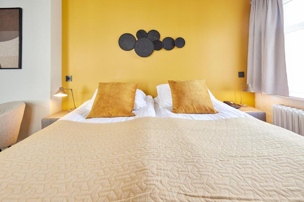 una camera da letto con un grande letto bianco con due cuscini di Hotel Frón a Reykjavik