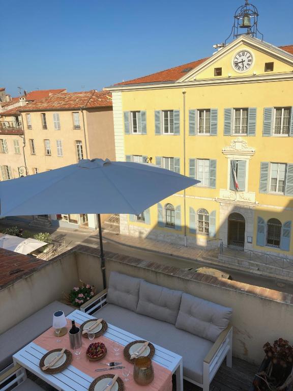 une table et un parasol devant un bâtiment dans l'établissement Enjoy Antibes, à Antibes