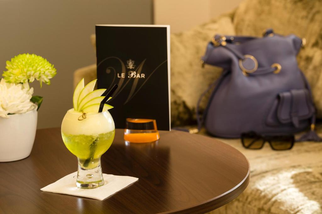 a table with a vase with a drink on it at Westminster Hotel & Spa Nice in Nice