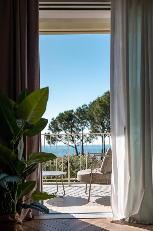 a room with a balcony with a view of the ocean at Bed & Breakfast LA HOME and Apartments in Moniga