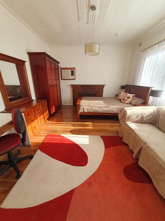 森伯里的住宿－Sunbury Central，卧室配有2张床和红色及白色地毯。