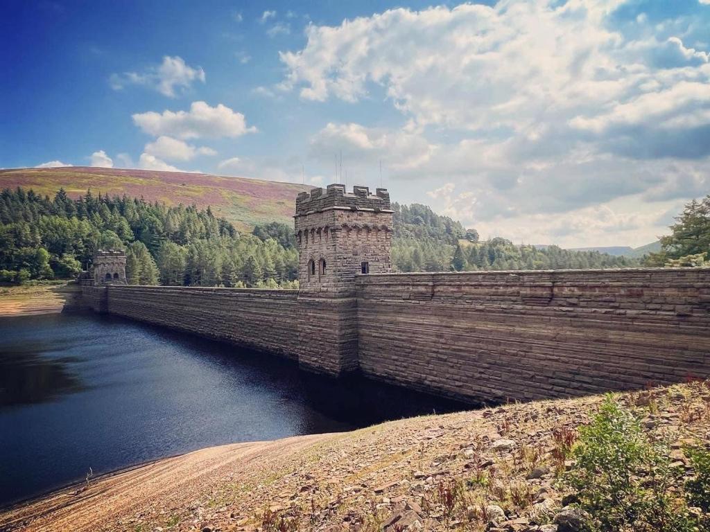 a stone bridge over a body of water at The Coach House & The Stables Holiday Homes Windy Bank Hall Green Moor Yorkshire Peak District in Wortley