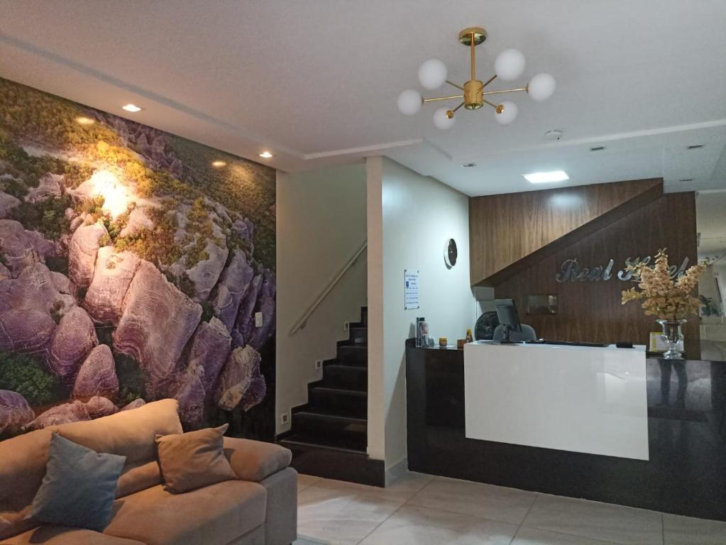 a lobby with a couch and a counter and stairs at Real Hotel Empreendimentos in São Raimundo Nonato