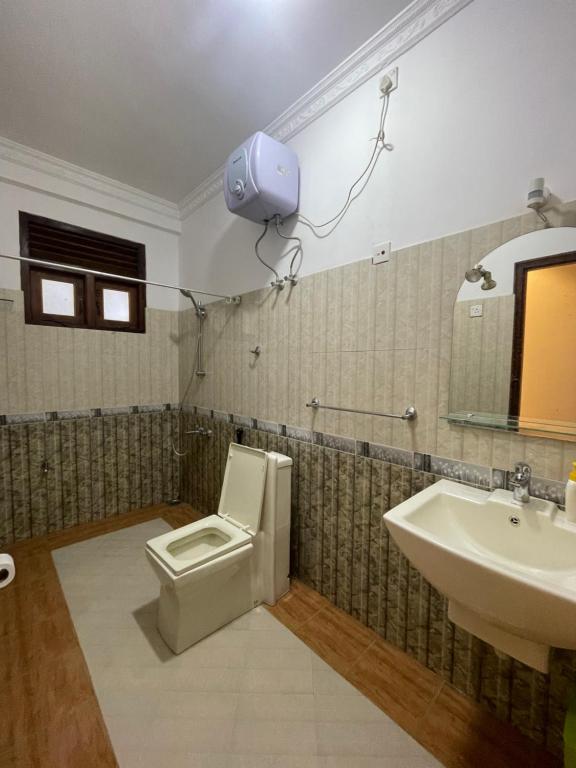 a bathroom with a toilet and a sink and a camera at Rusty Bunk Villa in Kandy