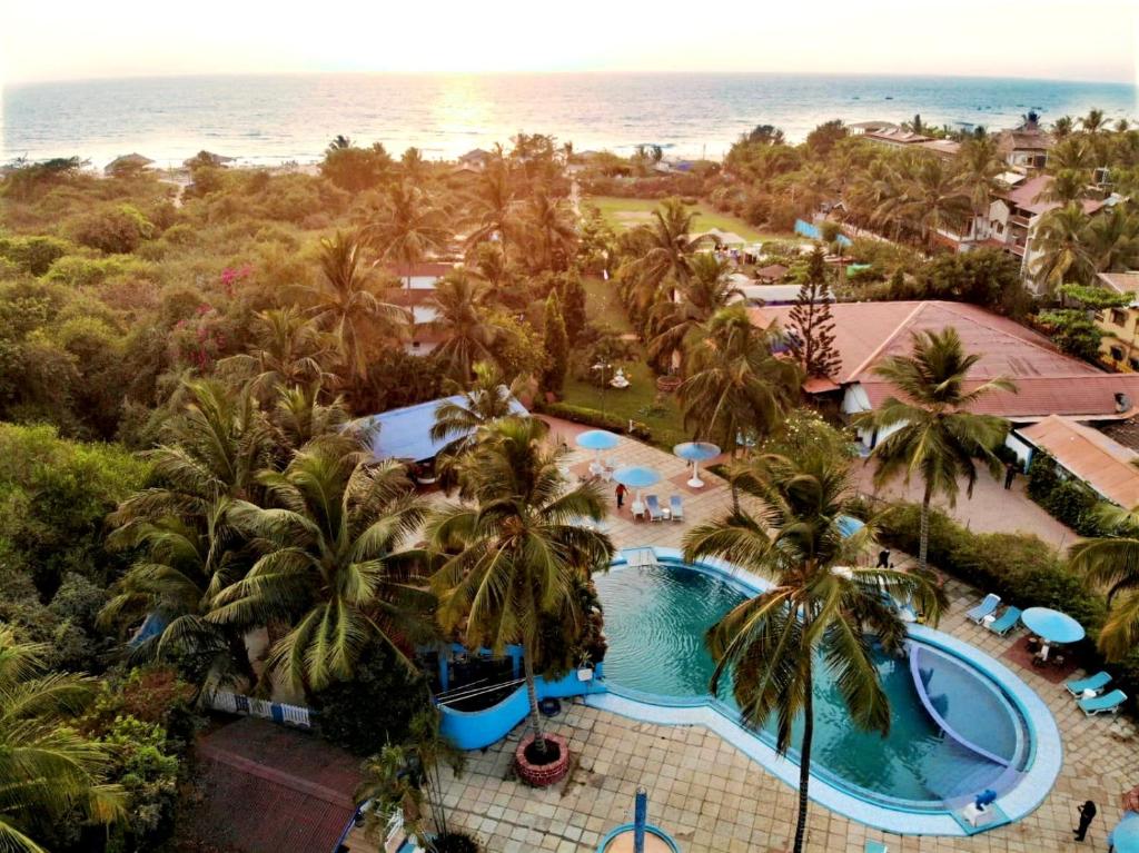 an aerial view of a resort with a pool and the ocean at Paradise Village Beach Resort in Calangute