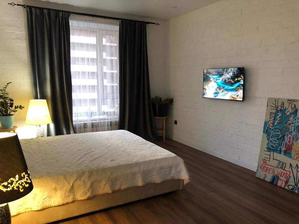 um quarto de hotel com uma cama e uma janela em Двухкомнатная квартира-студия em Prigorodnyy