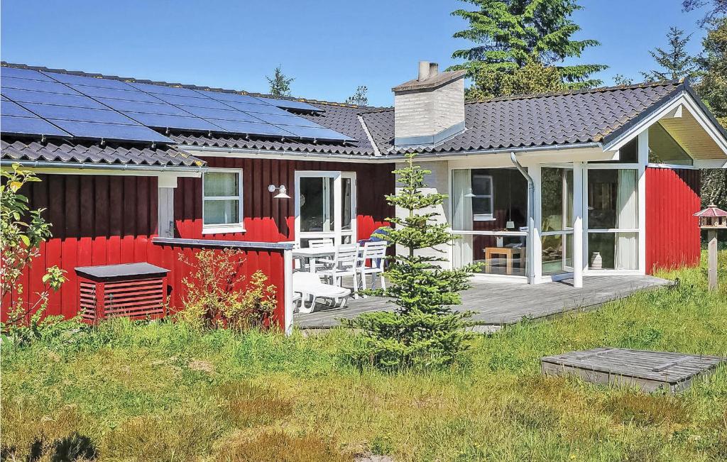 una casa roja con paneles solares. en Amazing Home In Fjerritslev With Wifi en Torup Strand