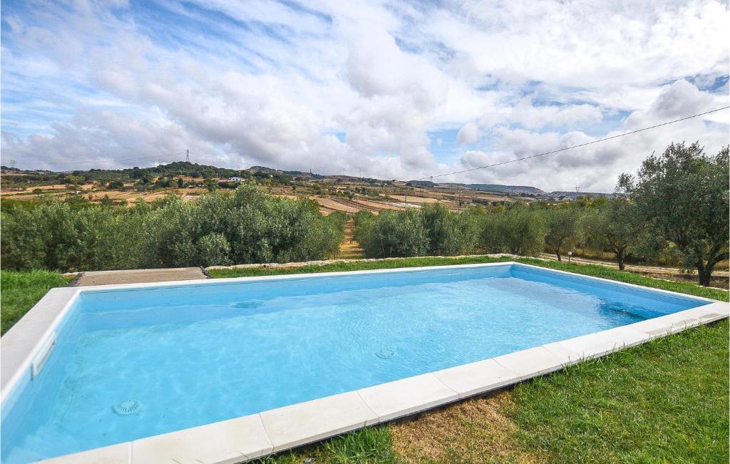 uma grande piscina azul na relva em Awesome Home In Monterosso Almo With Outdoor Swimming Pool, Wifi And 3 Bedrooms em Monterosso Almo