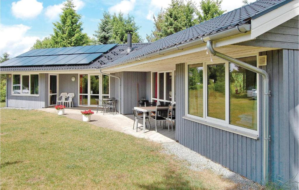 une maison avec une terrasse, une table et des fenêtres dans l'établissement Beautiful Home In Frvang With 3 Bedrooms And Wifi, à Fårvang