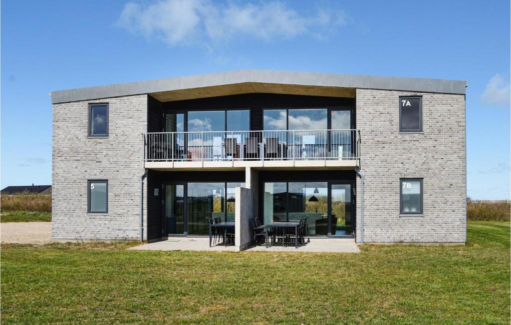 スナーヴィグにあるHoliday Home Ringkobing Xxxixのバルコニー付きの大きなレンガ造りの家です。