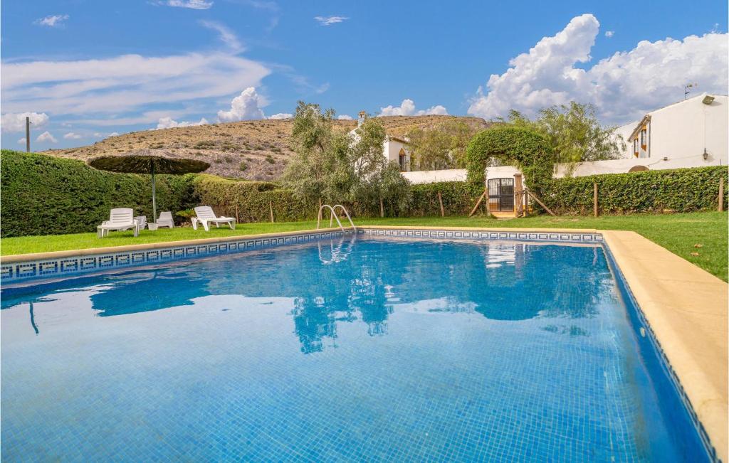 a large swimming pool in the yard of a house at Cozy Home In Teba With Kitchenette in Teba