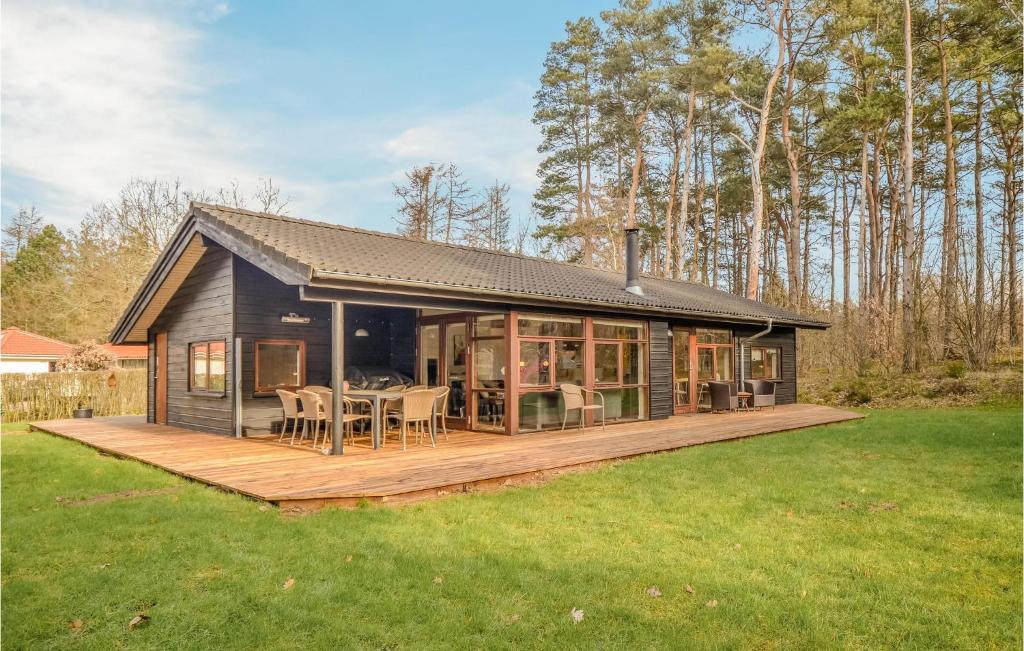 a house with a deck with a table and chairs at 4 Bedroom Gorgeous Home In Ebeltoft in Øksenmølle