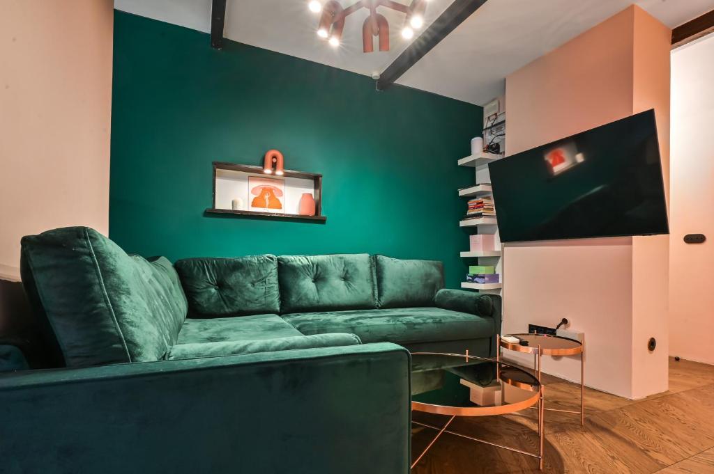 un soggiorno con divano verde e TV di Lozenetz Gem: Cozy 1-Bedroom Apartment in Sofia a Sofia