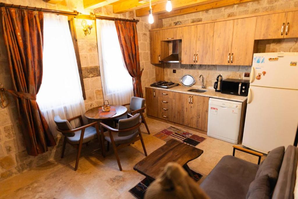 a small kitchen with a table and a refrigerator at Cappalace Stone House in Urgup