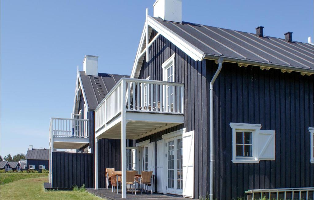 a black and white house with a porch and a balcony at Shjlandet in Gjern