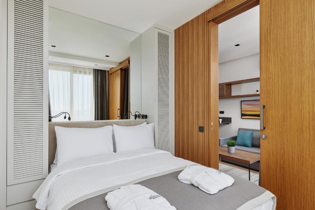 a bedroom with a large bed with two towels on it at Bayview Hills Luxury Residences in Tivat