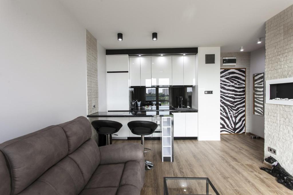 a living room with a couch and a kitchen at Apartament Bialystok in Białystok