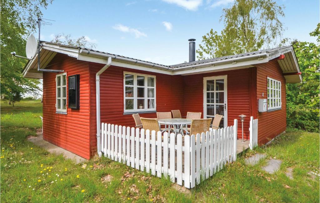 a red tiny house with a white fence at Awesome Home In Ebeltoft With 3 Bedrooms in Ebeltoft