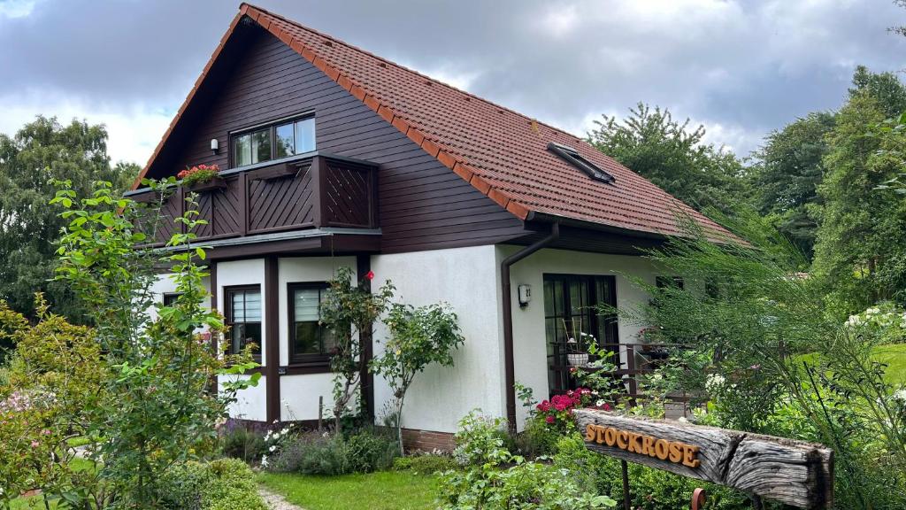 ein kleines weißes Haus mit braunem Dach in der Unterkunft Ferienwohnung Stockrose in Lohme