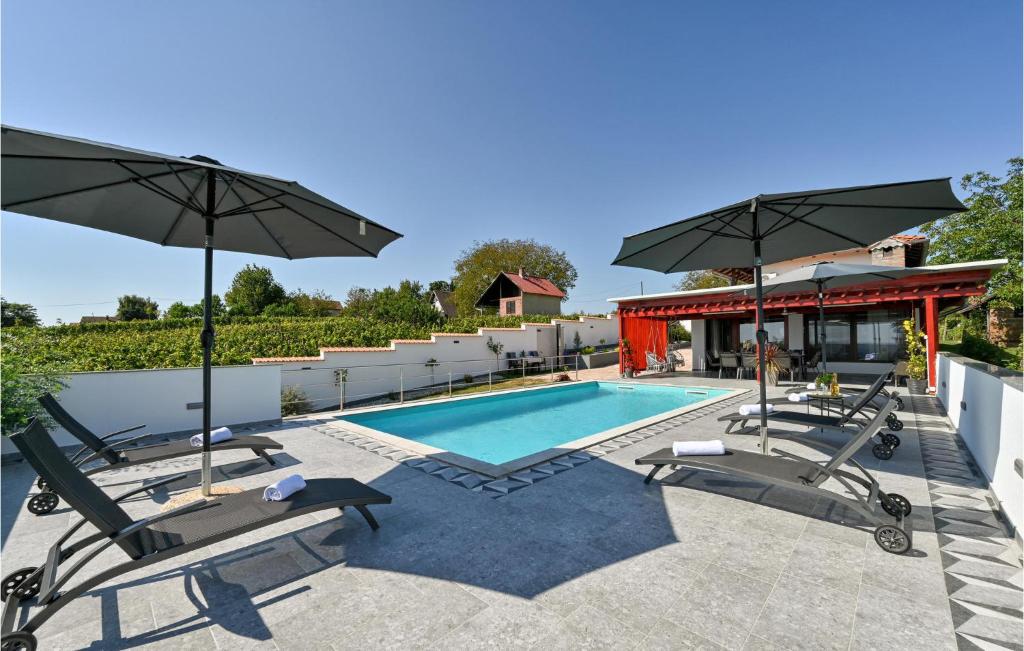 - une piscine avec des chaises longues et des parasols dans l'établissement Amazing Home In Sedlarica With Heated Swimming Pool, 