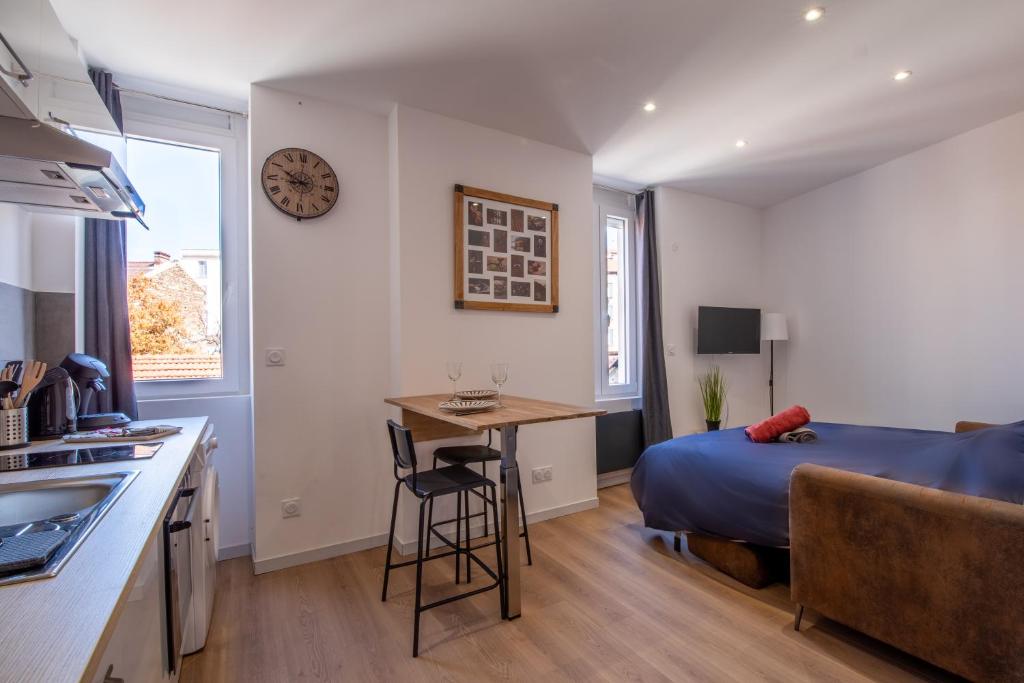 cocina y dormitorio con cama y escritorio en Le vintage 201 - Stationnement gratuit - Cosy et proche commodités, en Saint-Chamond