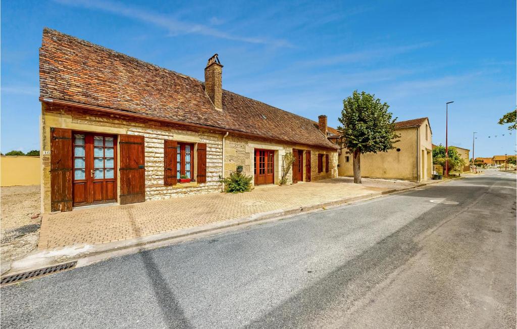 um velho edifício de tijolos ao lado de uma rua em Nice Home In St Pierre Deyraud With Outdoor Swimming Pool em Saussignac