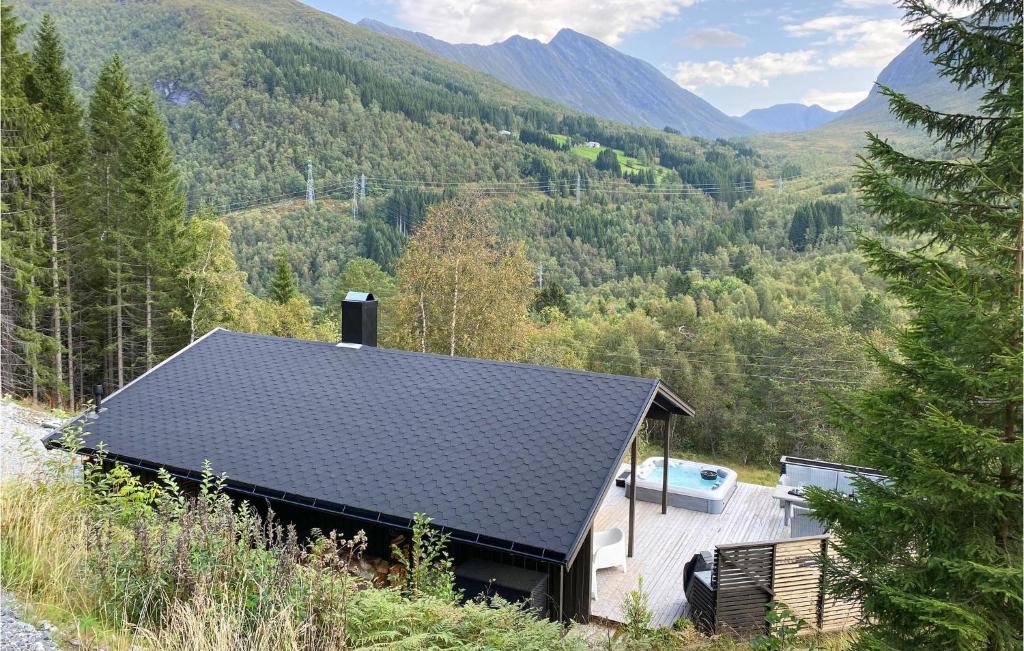 een huis met een zwart dak in de bergen bij Cozy Home In Stordal With House A Mountain View in Stordal