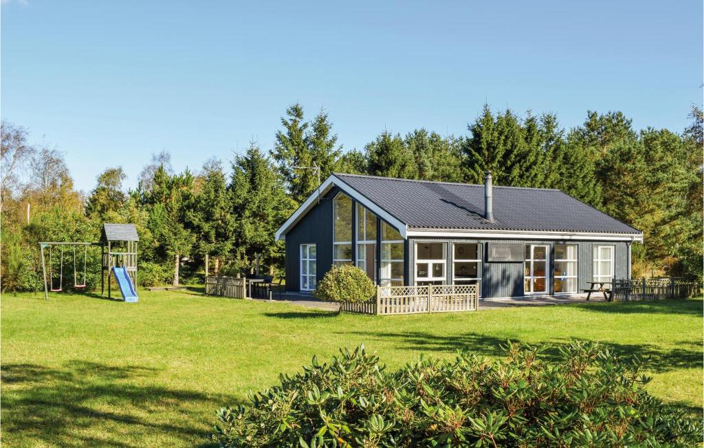 ein Haus mit einem großen Garten mit Spielplatz in der Unterkunft Stunning Home In Ebeltoft With Kitchen in Øksenmølle