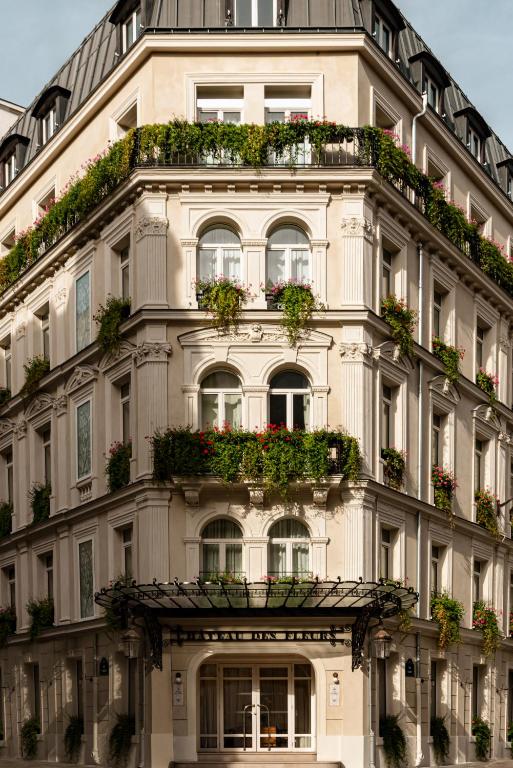 a tall white building with flowerpots on it at Château des Fleurs Hôtel & Spa Paris in Paris