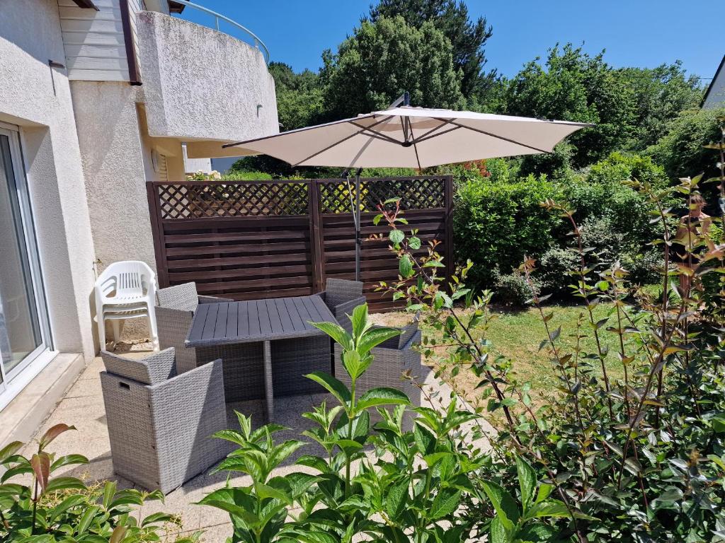 un patio con mesa y sombrilla en Appartement "La Mouette" 3 etoiles, en Saint-Philibert
