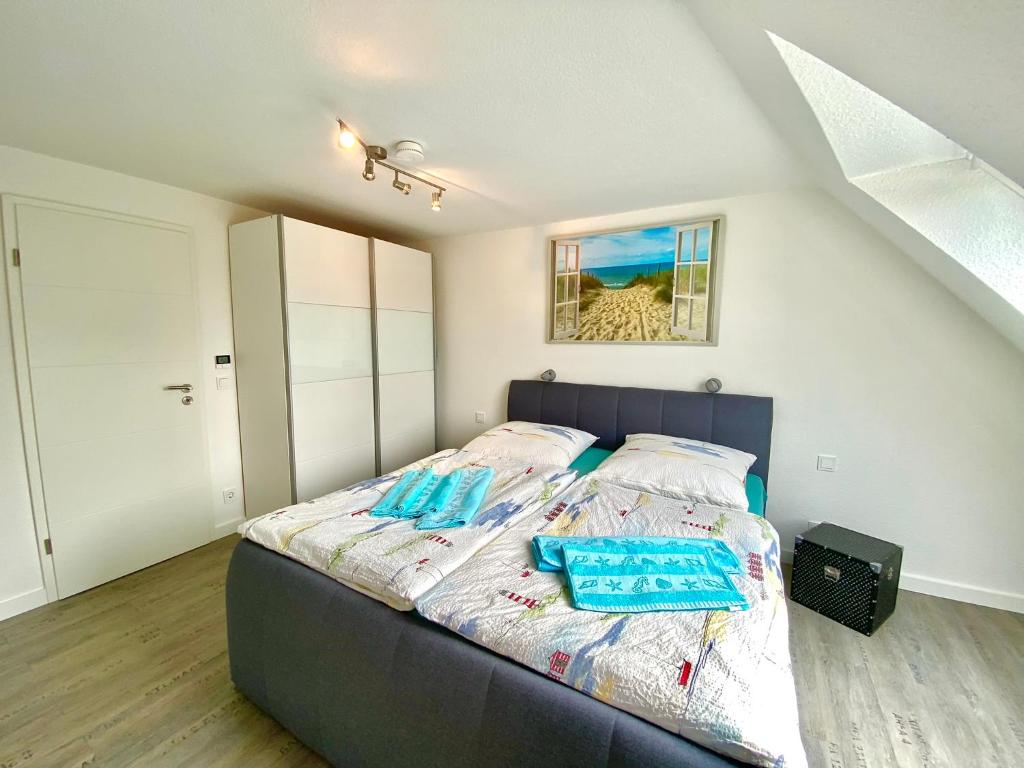 een slaapkamer met een bed met een blauw hoofdeinde bij Ferienwohnung, schön & modern, Strand/ -Grimmershörnbucht in Cuxhaven