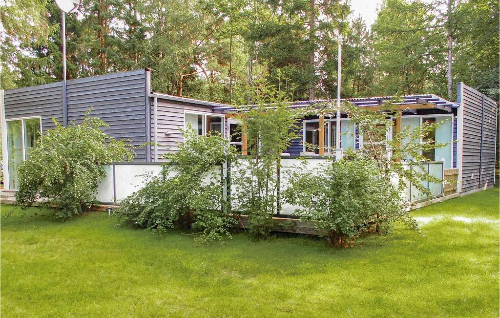 Nice Home In Ebeltoft With Kitchen في Øksenmølle: منزل صغير في ساحة بها اشجار