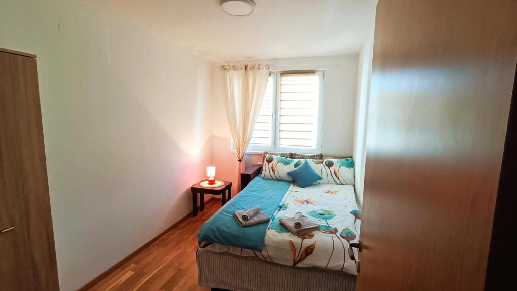 - une petite chambre avec un lit et une fenêtre dans l'établissement Felix Apartment Istocno Sarajevo, à Vranješ
