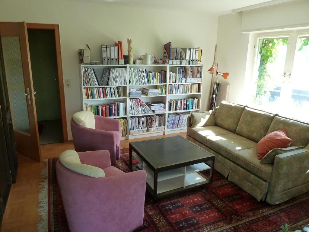 a living room with a couch and chairs and a book shelf at Im Efeu in Großniedesheim