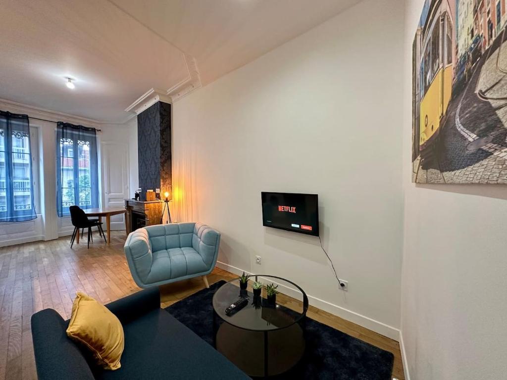 ein Wohnzimmer mit einem Sofa und einem TV an der Wand in der Unterkunft Cosy appart Lyon Part Dieu Félix 2 in Lyon