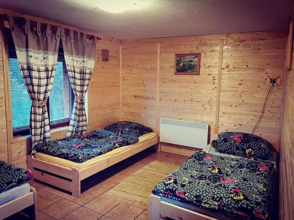 a room with two beds and a window at Chata Hrabovská 