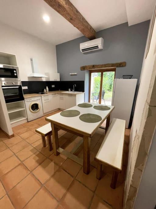 a kitchen with a table and chairs in it at Superbe appartement cosy avec jardin in Nîmes