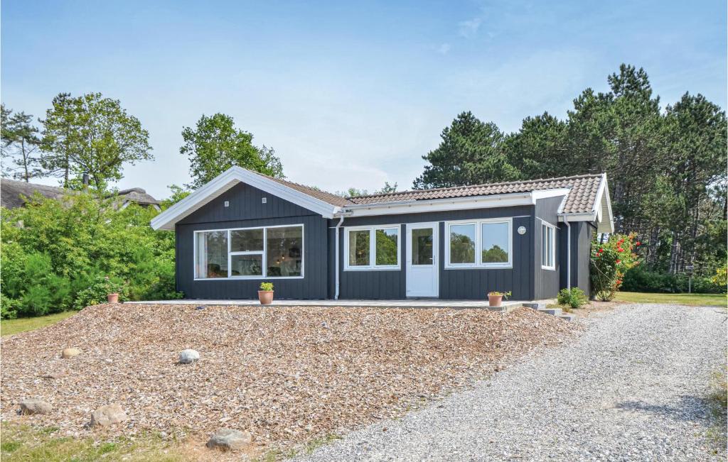 a small blue house with a gravel driveway at Stunning Home In Ebeltoft With 4 Bedrooms, Sauna And Wifi in Ebeltoft