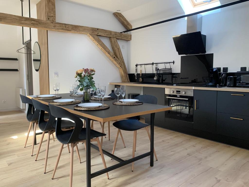 jadalnia ze stołem i krzesłami oraz kuchnia w obiekcie Le pinot, 30 min de Reims w mieście Dormans
