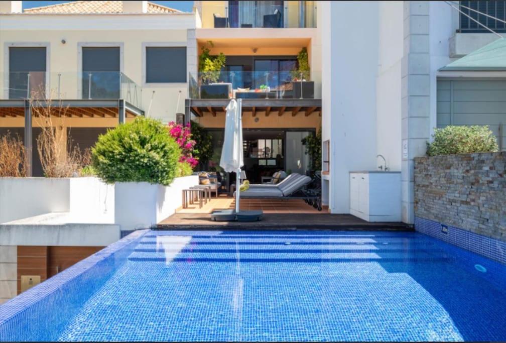 una piscina en el patio trasero de una casa en Luxury Villa 3+1 BD & pool/jacuzzi/golf/beach en Vale do Lobo