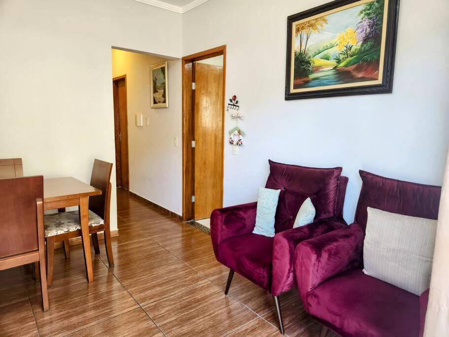 a living room with a purple couch and a table at Básico e Aconchegante in Itajubá