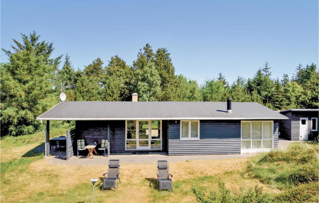 a house with a picnic table and chairs in the yard at Jydehuset in Slettestrand