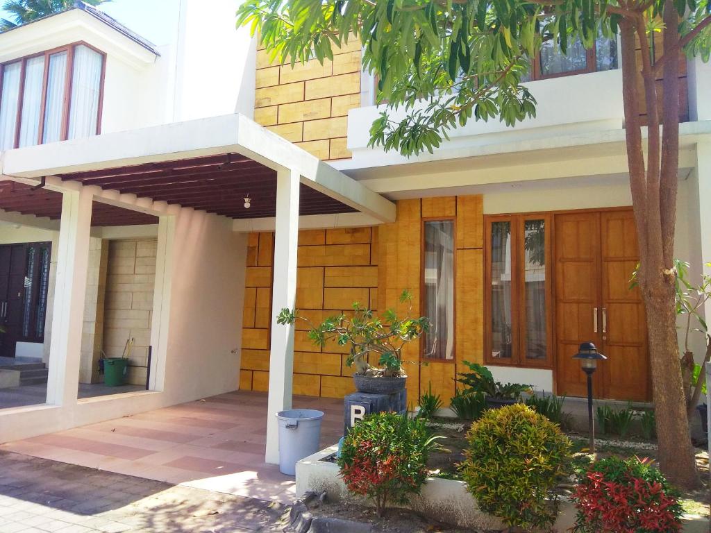 Casa con puerta de madera y porche en Omah Dixy Family Homestay by FH Stay en Bantul