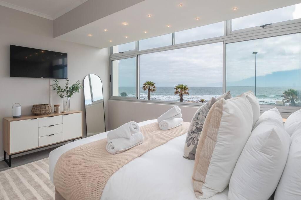 een slaapkamer met een bed en uitzicht op de oceaan bij Seaside Studio in Mouille Point in Kaapstad