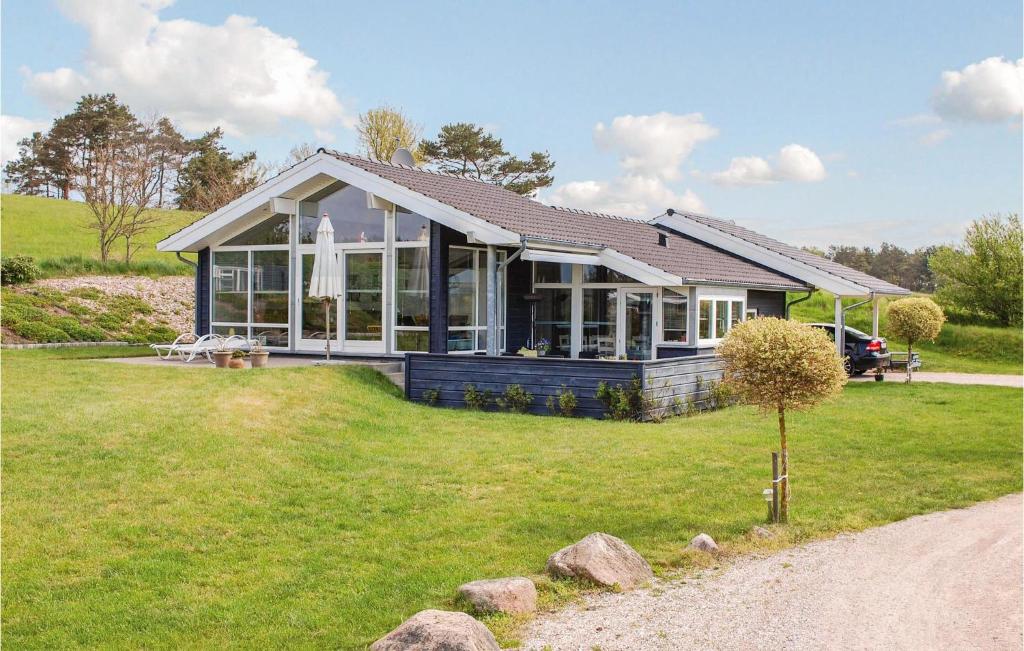 エーベルトフトにあるStunning Home In Ebeltoft With 4 Bedrooms, Sauna And Wifiの芝生の上に窓がたくさんある家