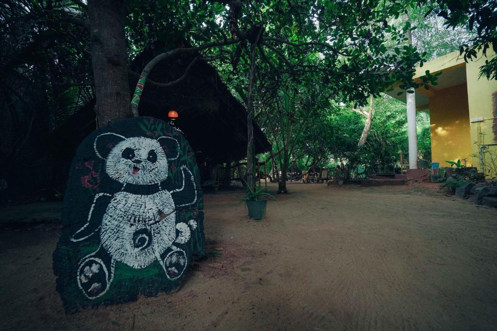 a post with a teddy bear painted on it at The Last Stop Backpackers Hostel in Auroville