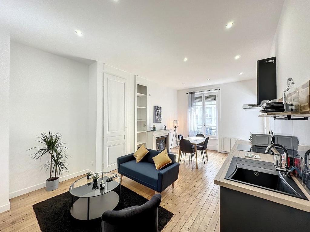 un salon avec un canapé bleu et une cuisine dans l'établissement cosy appart - Préfecture Lyon - Servient 1, à Lyon