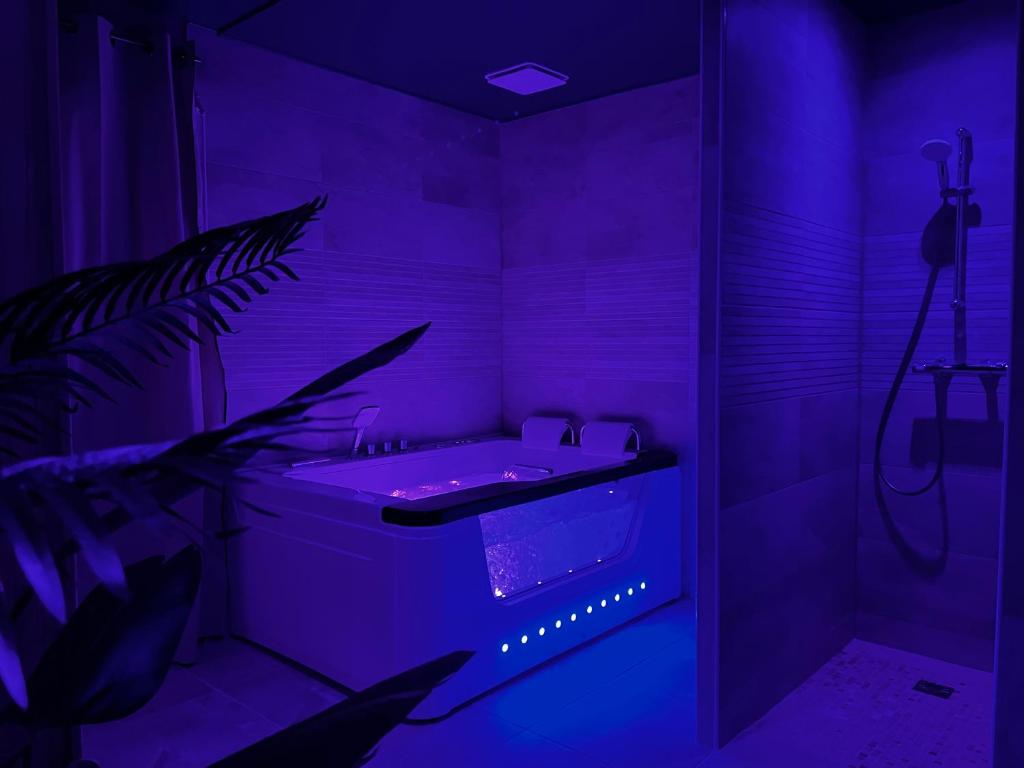 baño púrpura con lavabo y planta en Appartement Deluxe - Spa & Sauna en Trégastel