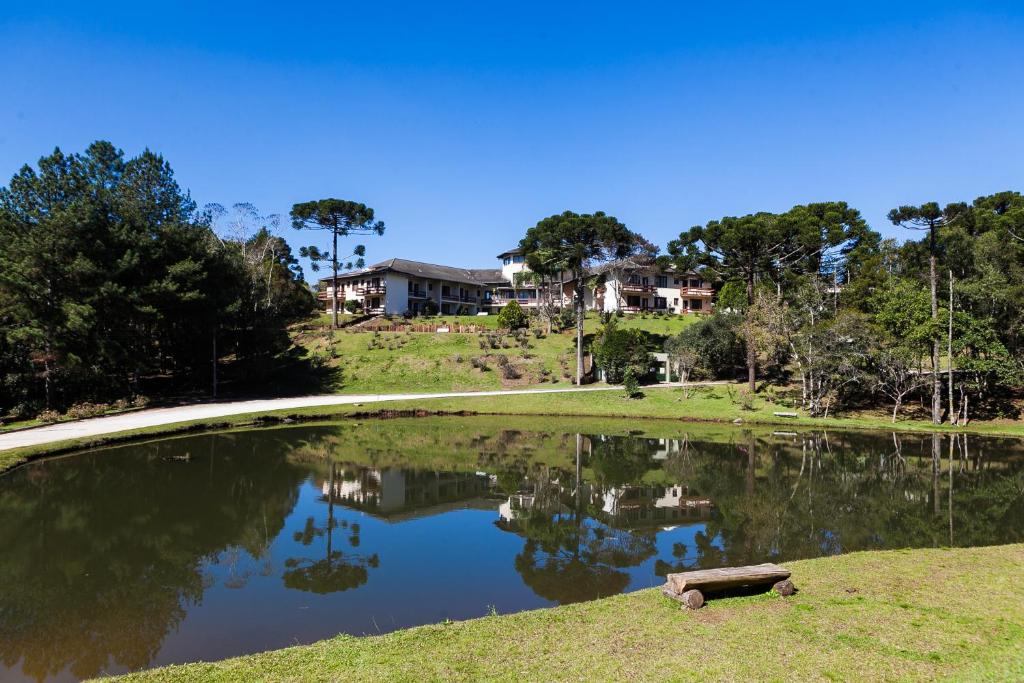 a pond of water with a house in the background at Hotel Estancia Betania in Colombo