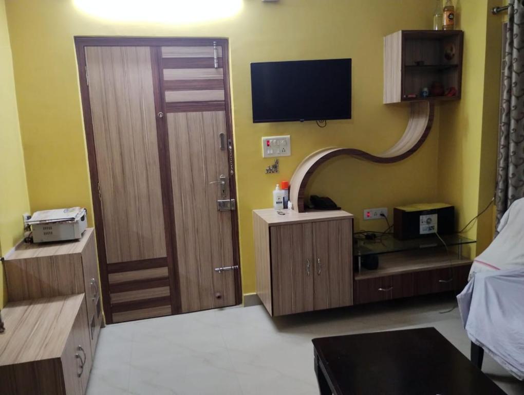 a room with a door and a television on the wall at Asha vihara Phase-2 in Muzaffarpur